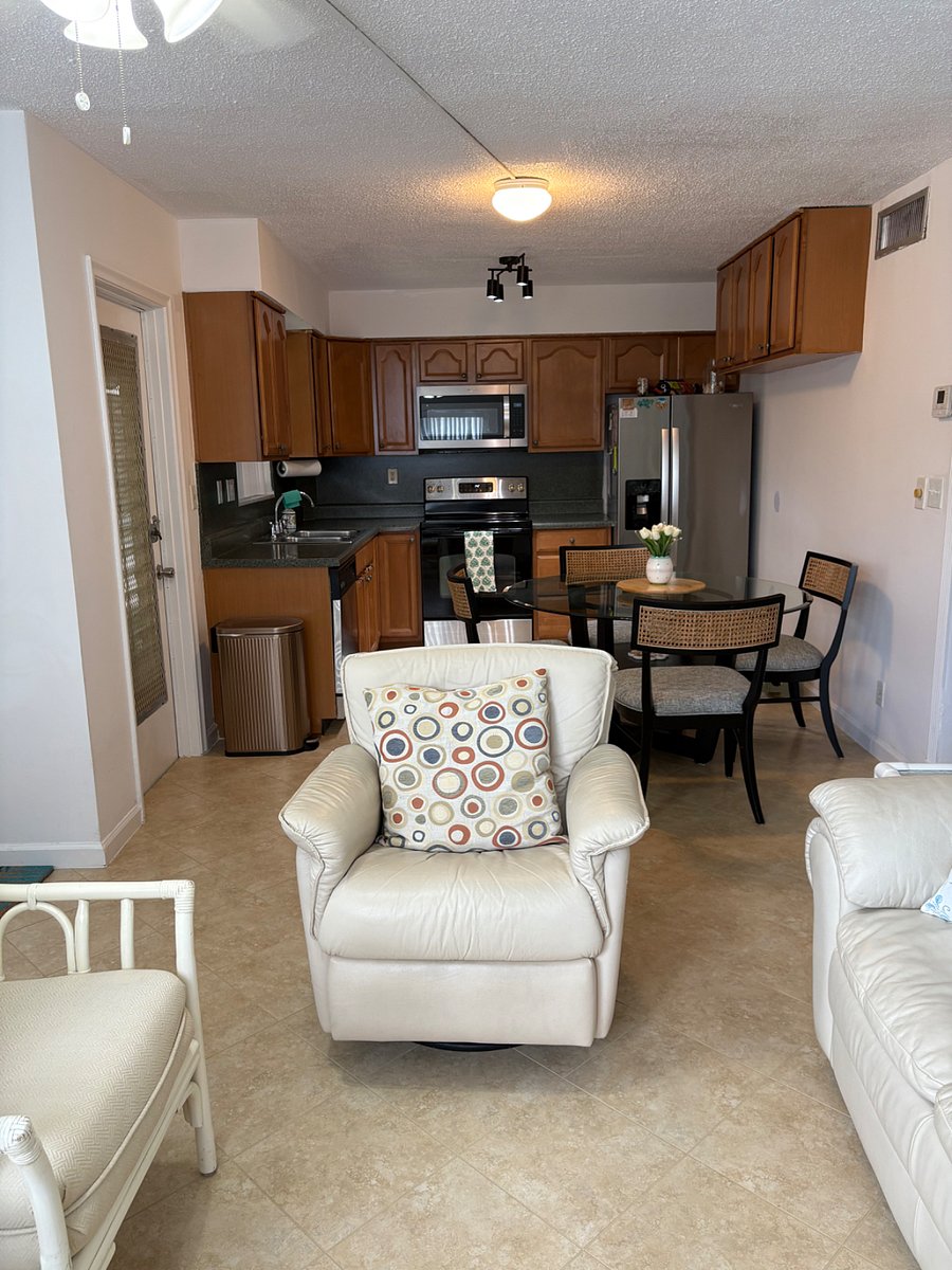 View of kitchen from living room. Shows recliner chair. 