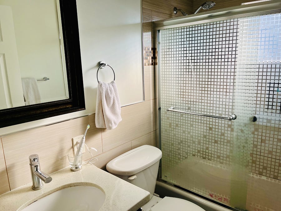 Full bathroom with shower, bath tub, toilet, mirror, towels etc.