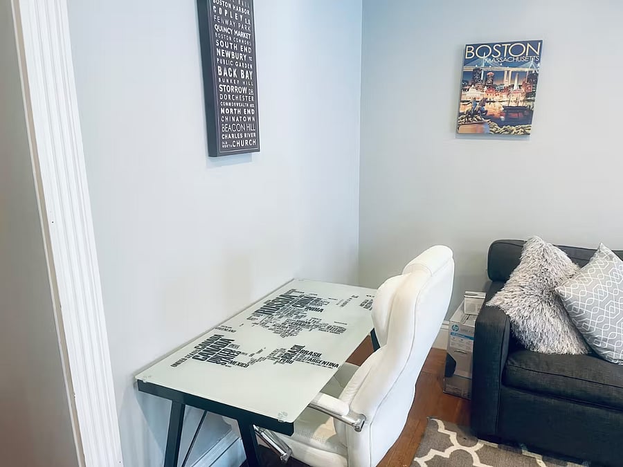 Office area with desk and plush leather white desk office chair. Including HP Printer and a Voice activated Google Home Mini.