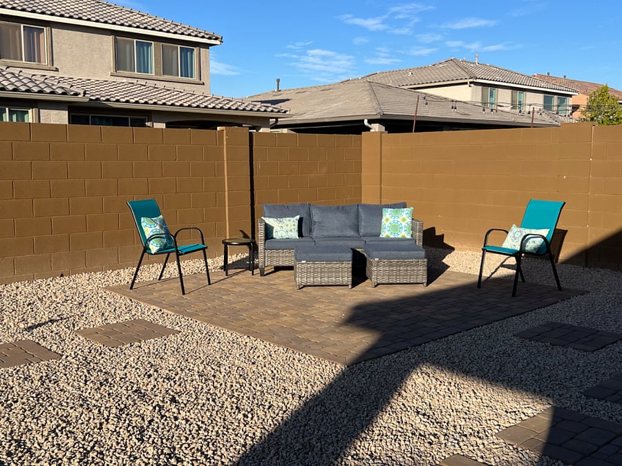 Outdoor sitting area with couch, ottomans, chairs, and pillows