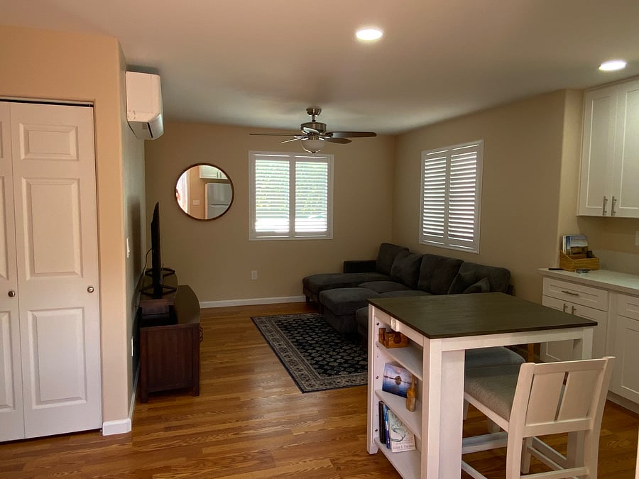 Cozy living area with shutters in windows and Air Conditioning/Heating Unit