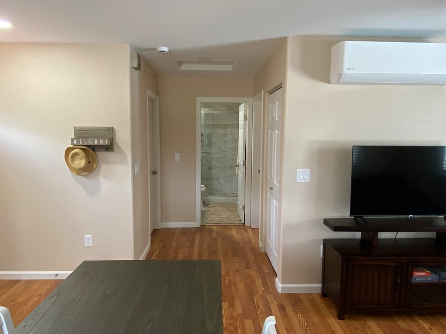 Short walkway leading to restroom and both bedrooms, with laundry room to the right.