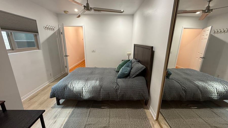 queen size bed with walk in closet to right and large mirror sliding doors