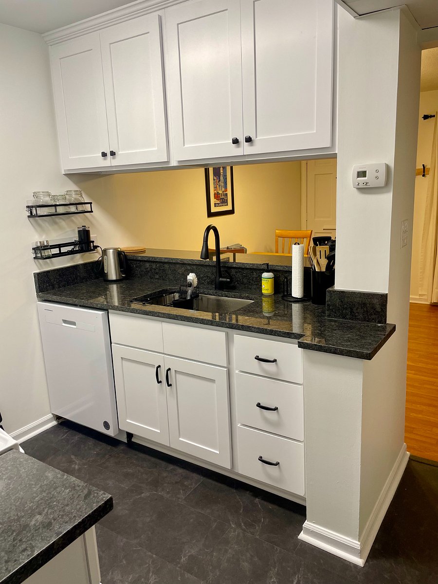 Kitchen with full sized dishwasher, pots, pans, utensils, and basic starter set of selected items, including coffee, tea, sugar, salt and pepper.