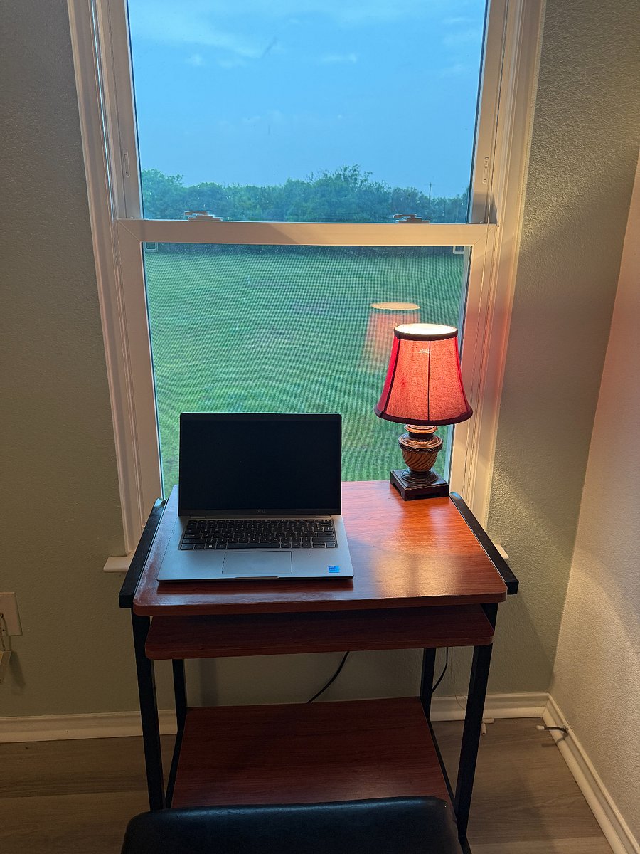Work table in master bedroom with bluebonnet flowers view of backyard 2 acres