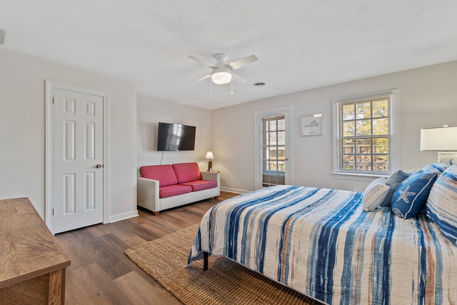 PRIMARY BEDROOM W. LVP FLOORS, ACCESS TO 2ND STORY DECK, CLOSETS AND PULL OUT COUCH