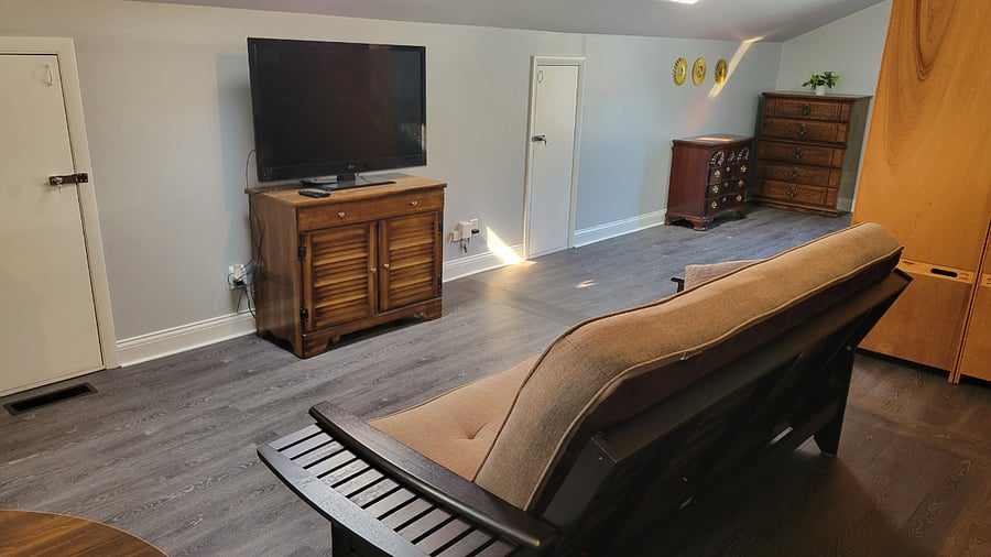 Relax with a TV equipped with Firestick for streaming, a collection of DVDs, and a comfy futon for lounging or extra sleeping space.
