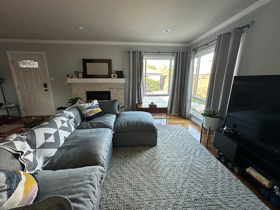 Cozy living room with plenty of natural light, a 65" tv and comfy couch perfect for napping, curling up with a book, or catching up with your favorite show