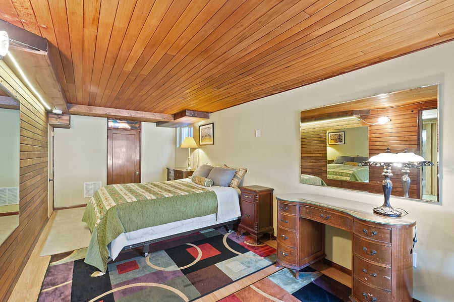 Comfortable basement bedroom with queen size bed, desk, 90% rug and carpet.