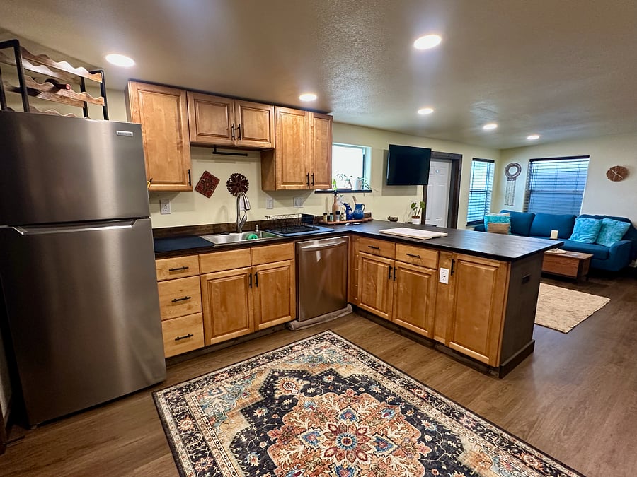 Kitchen features full size refrigerator, dishwasher, toaster oven and cook top, instant pot, coffee maker, tea kettle, and more. 