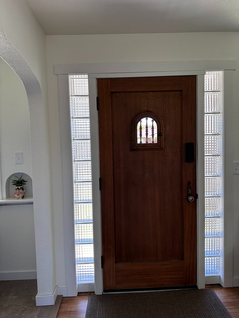 The front entrance has an unique vintage door. The glass block allows extra light to filter into the living space.