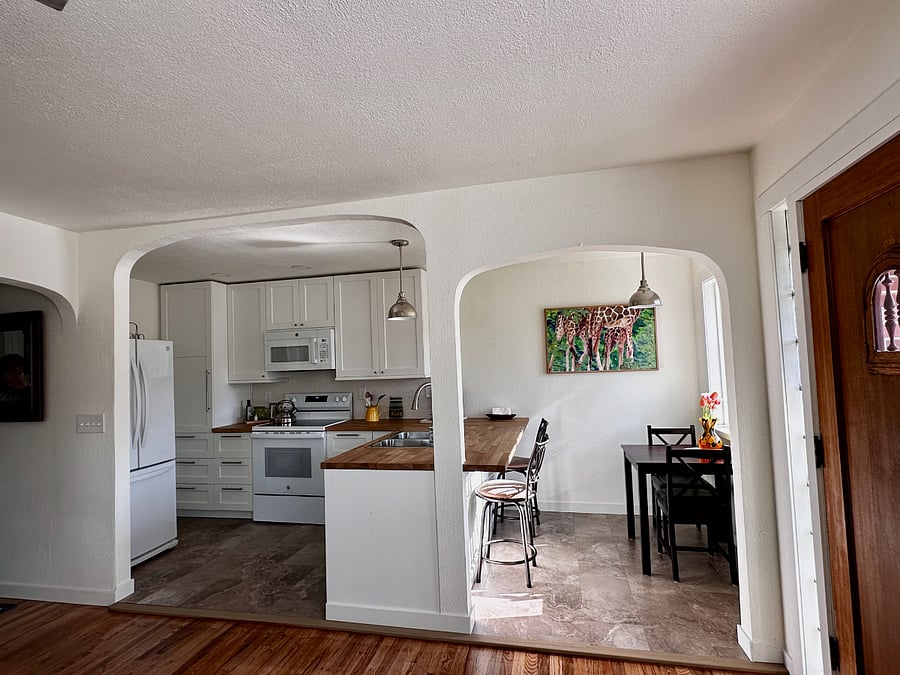 This bright and open layout connects the kitchen, dining, and entry spaces with graceful archways. All the essentials ready to go from coffee maker to cookware.