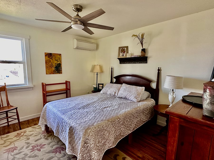 Comfortable queen size bed, bedside lamps and artwork featuring Tacoma scenes and other fanciful images.