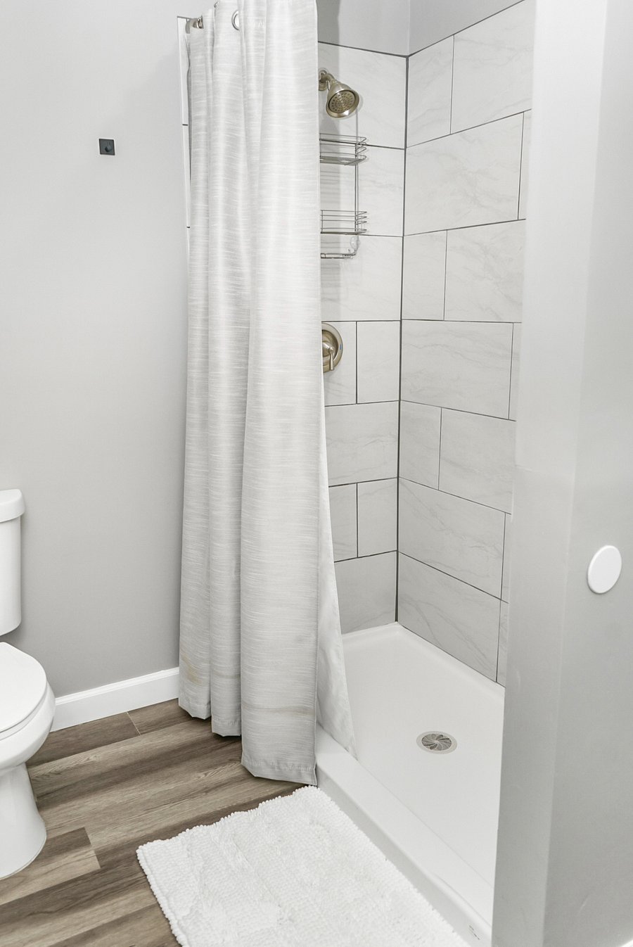 Spotless and modern walk-in shower with sleek tilework and soft white accents for a spa-like feel.