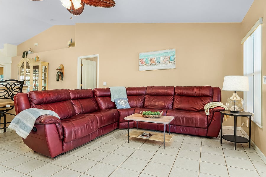 Living room has  65"TV and sliding door access to lanai and pool