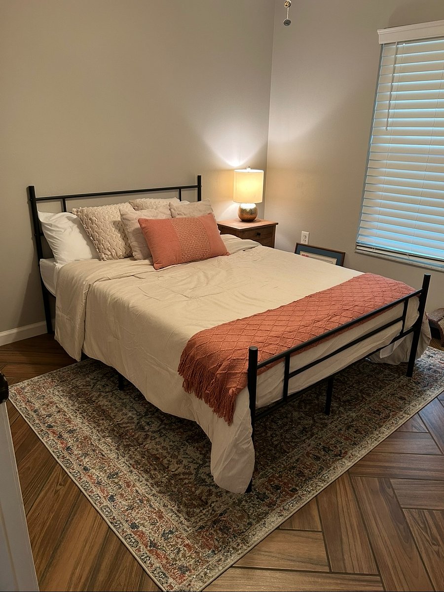 Comfortable guest room with queen bed, custom blinds, and linens provided.