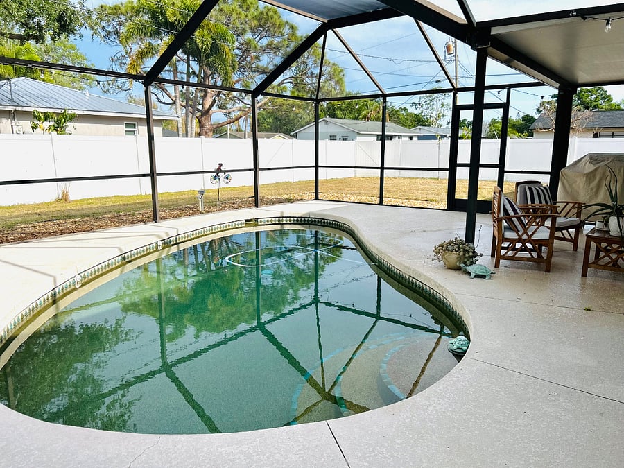 Screened lanai and river rock-bottomed pool perfect for relaxing off-shift.