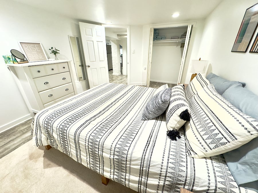 Roomy bedroom with queen bed, dresser, closet, double nightstands and blackout curtains