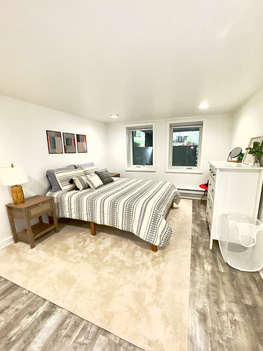 Roomy bedroom with queen bed, dresser, closet, double nightstands and blackout curtains