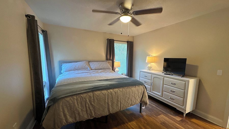 Primary Bedroom with King Bed, new Hybrid Mattress, Blackout Curtains, Smart TV, and ceiling fan. 