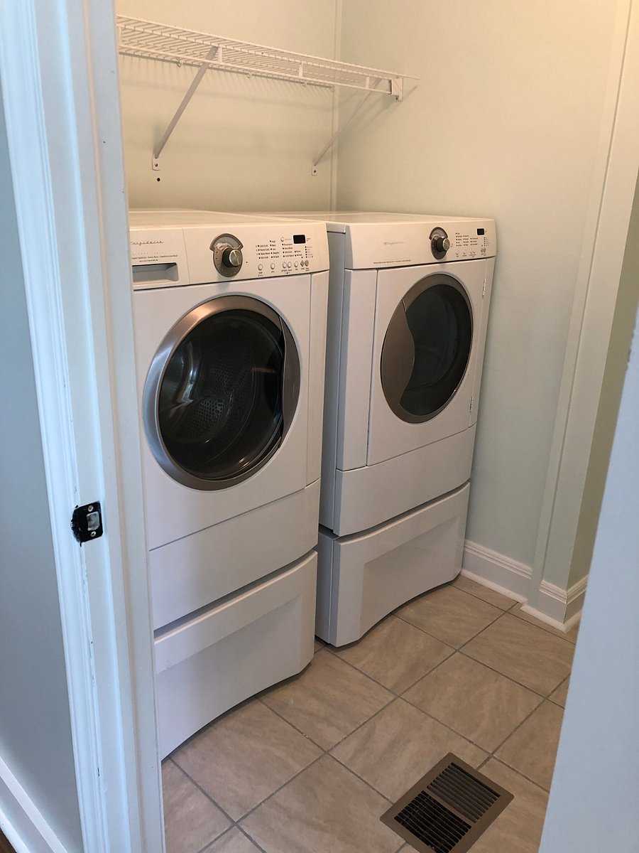 Washer and dryer in laundry closet.  Closet has wire racking for storage and hanging clothes.