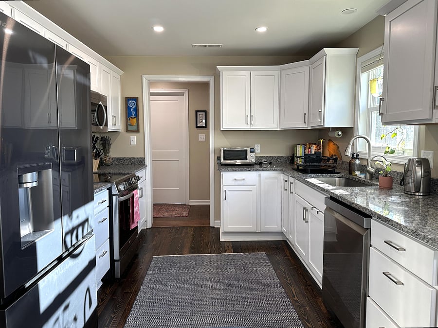 Kitchen- pantry next to fridge contains cleaning supplies, extra linens, and storage space.