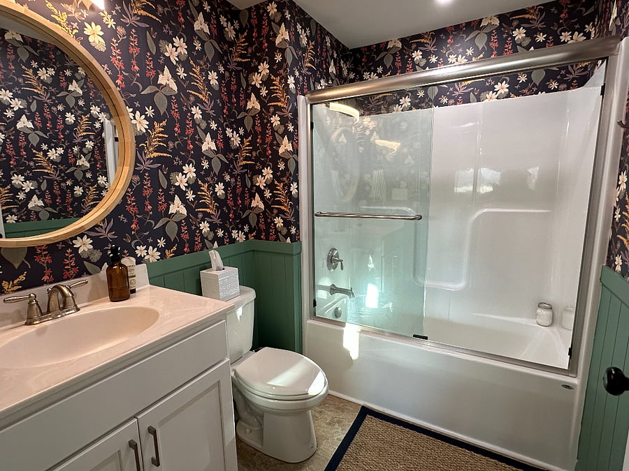 Secondary bathroom and tub- the wallpaper was designed by a local artist and is all native wildflowers. Can you name them all? Storage beneath sink contains extra toiletries.