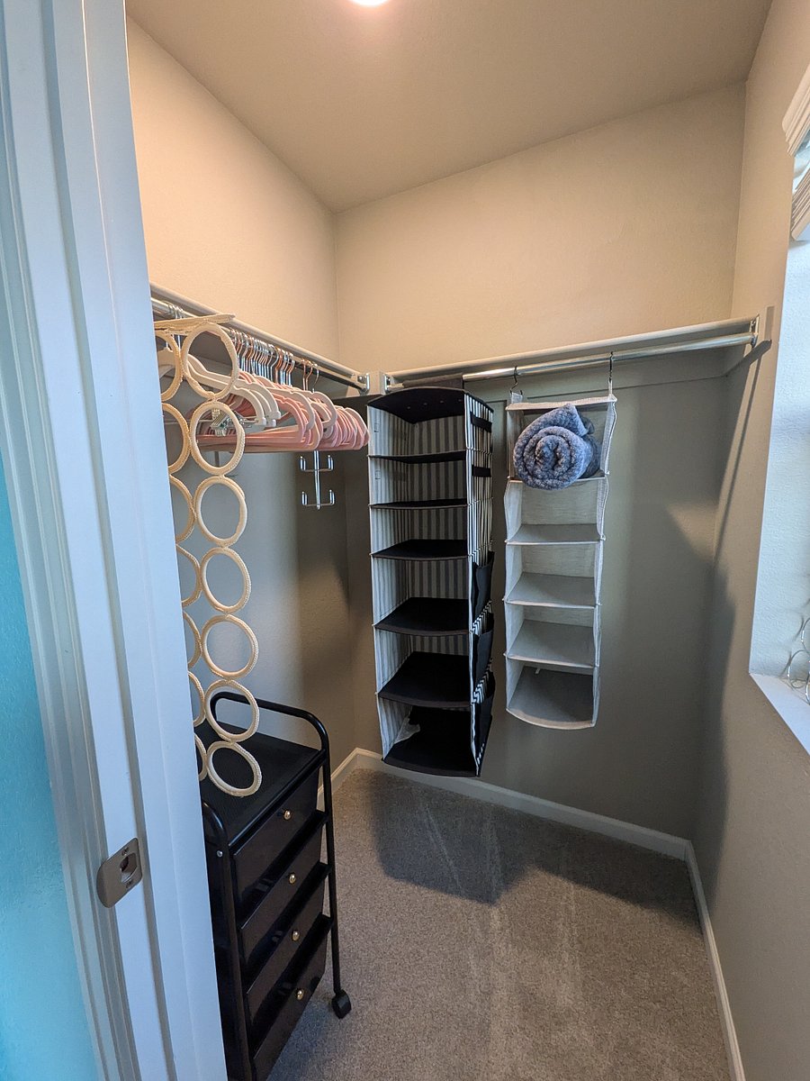 Glacier room walk-in closet, includes hangers, organizers, and laundry bin.