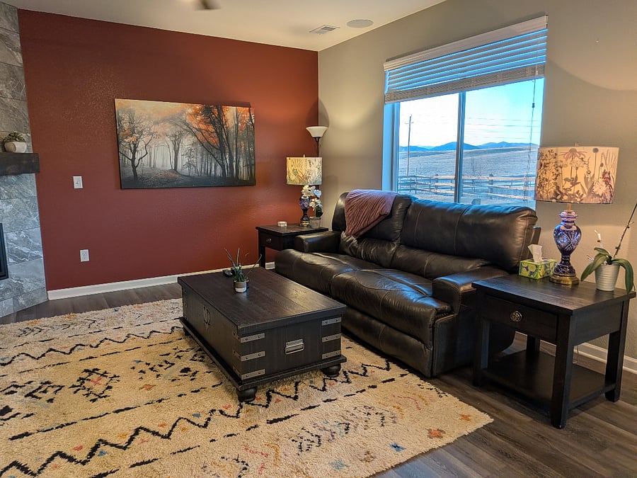 The main floor living area has a reclining couch, an extendable coffee table, and end tables,