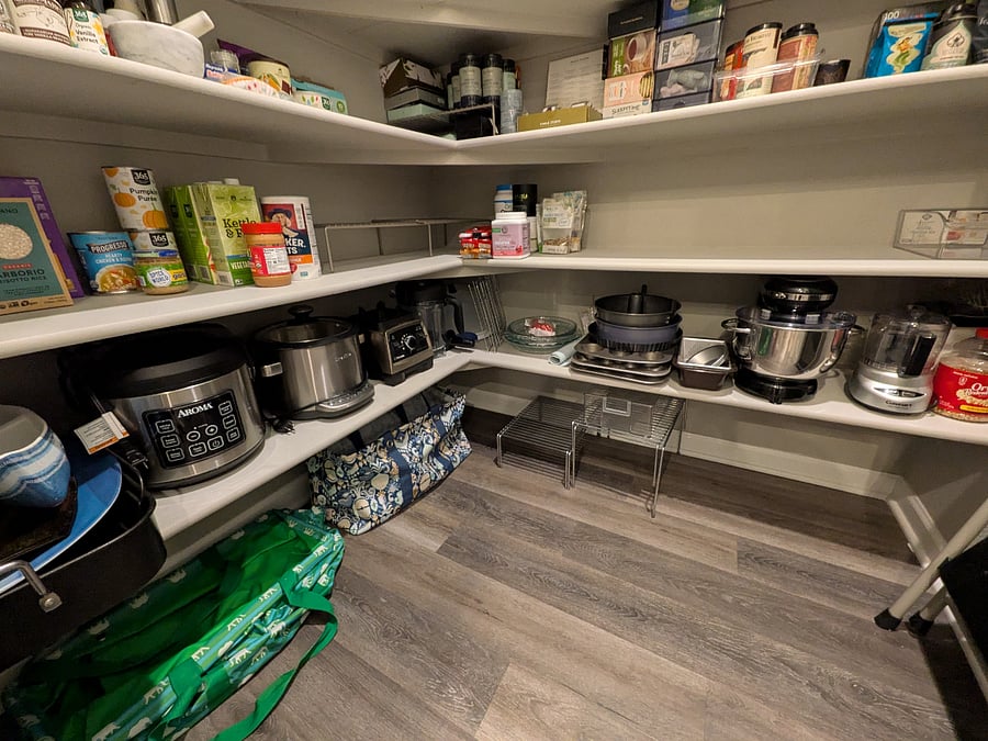Walk-in pantry comes loaded with kitchen appliances and baking equipment, including a stand mixer.