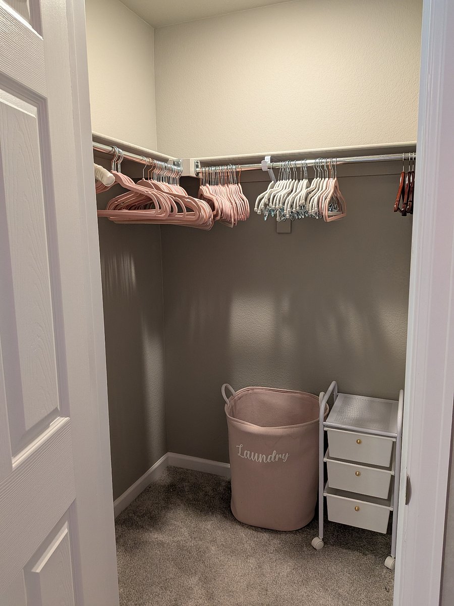 Canyon room walk-in closet, with hangers, organizers, and laundry basket.