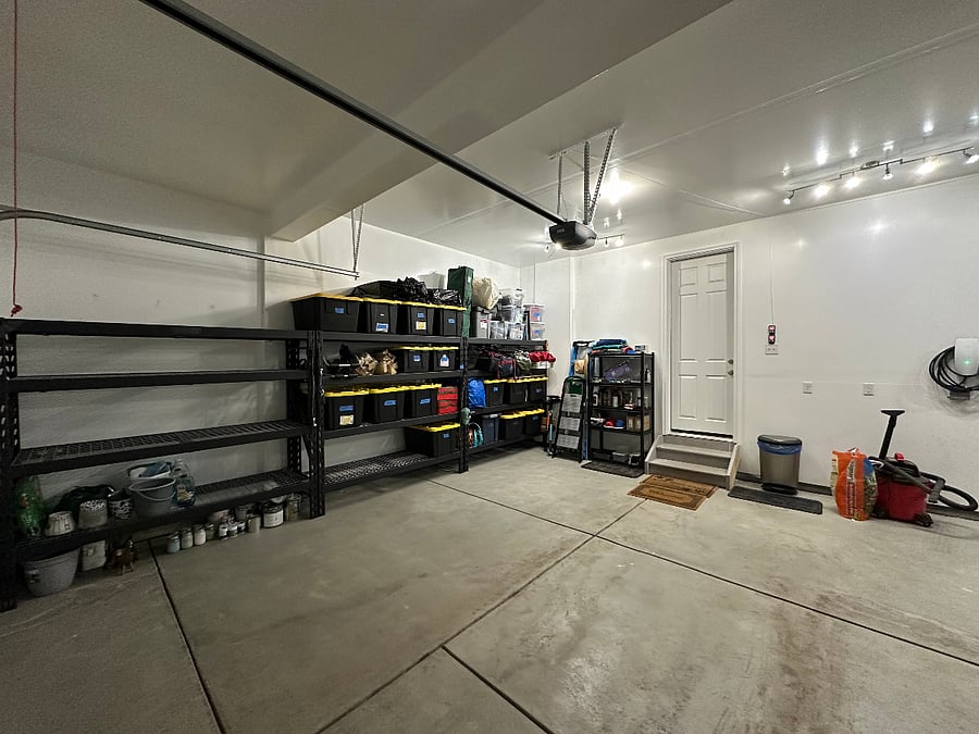 Three car finished garage, comes with storage shelves, tools, and gardening equipment.