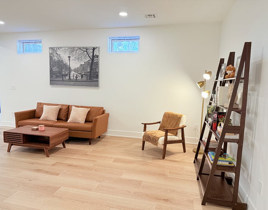 Living room with comfortable sofa, coffee table, smart TV, and cozy reading nook, all separated from the owners