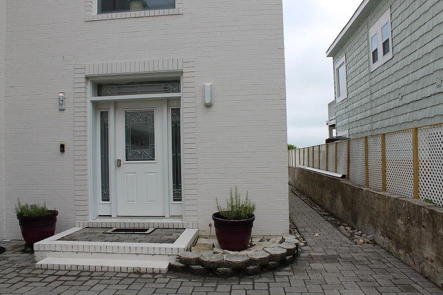 Street side door with walkway on the side of the house to the beach