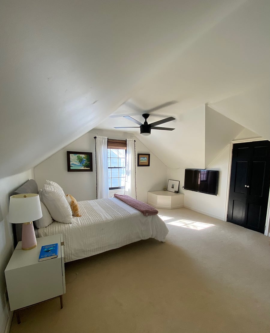 Upper level master bedroom with a spacious walk-in closet and TV on the wall.