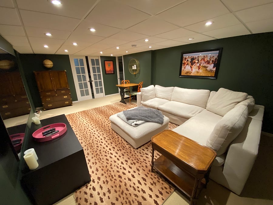 Lower level family TV room with laundry room behind the French sliding doors and a heated tile floor bathroom.