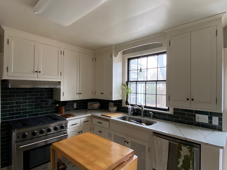 Carrera marble counter top, white cabinets and coffee/tea bar with pot rack on the other side of the kitchen