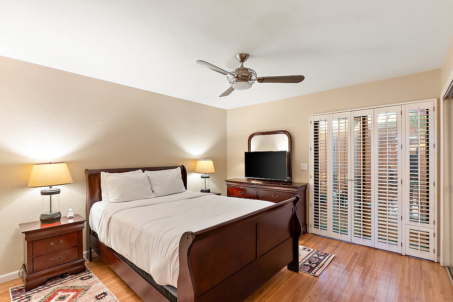 If climbing a flight of stairs after a long day of golfing, hiking, or aggressively day-drinking sounds like absolute torture, this room is your sanctuary. Located right on the main level, it features a ridiculously comfortable queen bed and its own Smart TV for mandatory evening dissociation.
But the real MVP here? Those massive, louvered shutter doors. Not only do they give the room a cool, breezy Southwest vibe, but they open directly onto the private patio and laundry room. Efficient, quiet, and perfectly set up for pure recovery.