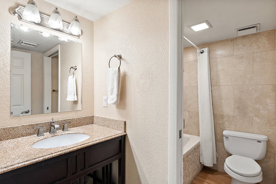 This main floor bath is squeaky clean, totally functional, and features a fully tiled tub and shower combo. If you actually prefer a solid soak after a long day of hiking or golfing, you're covered.
The vanity area offers plenty of counter space to spread out your toiletries and a massive mirror to check your sunburn before heading out for drinks.