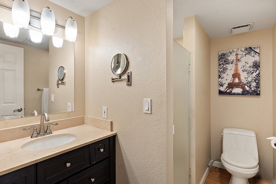 The en-suite bathroom has a dedicated walk-in shower. It features a frosted glass door, plenty of counter space, and a massive vanity mirror to check your post-shift dark circles. Most importantly? There is no claustrophobic, cheap plastic shower curtain sticking to your legs. It does exactly what it needs to do: provides a hot, straightforward reset before you collapse into that king-sized bed.