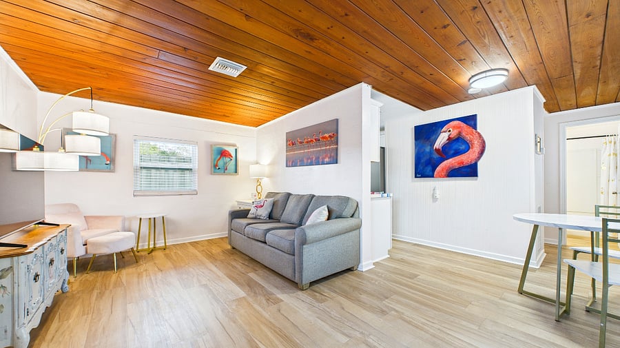 Bright living space with Smart TV, dedicated workspace, and original wood ceiling