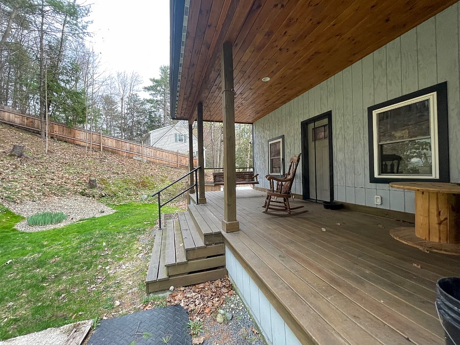 Covered back porch in fenced in yard