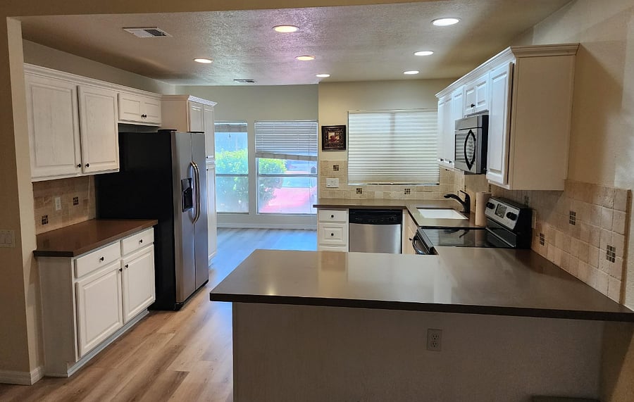 Open concept kitchen with stainless steel appliances. Lots of cabinets and separate floor to ceiling pantry.