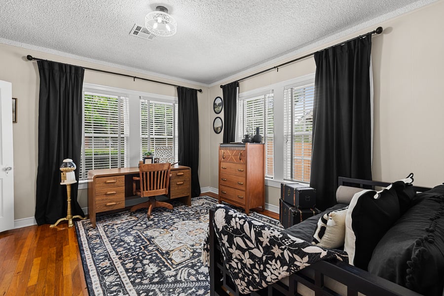 Secondary bedroom with large desk and twin sized bed.