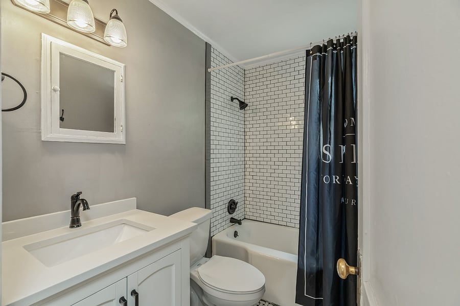 Deep cast iron tub with tile surround.