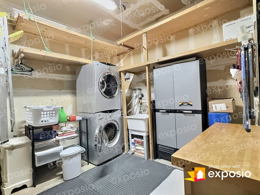 Laundry room w workbench and storage.
