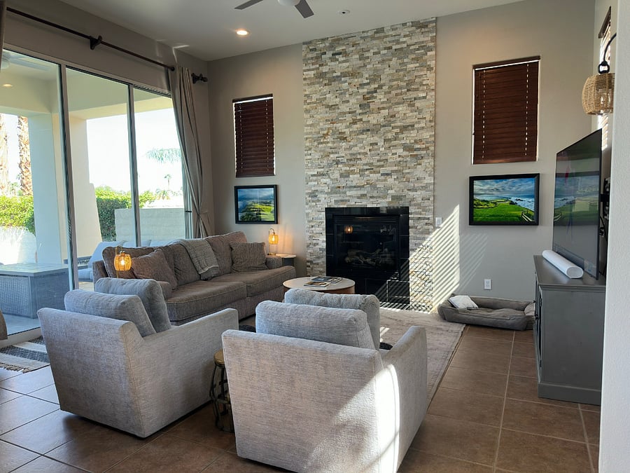 Family room with swivel chairs, fireplace, and ceiling fan.