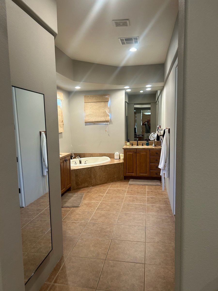 Primary bathroom with double sinks, separate toilet room, walk-in shower, full-length mirror and soaking tub.