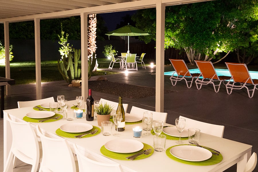 Oversize backyard features two dining areas. This one seats 8 and is adorned by charming cafe lights for enchanting evening dining.