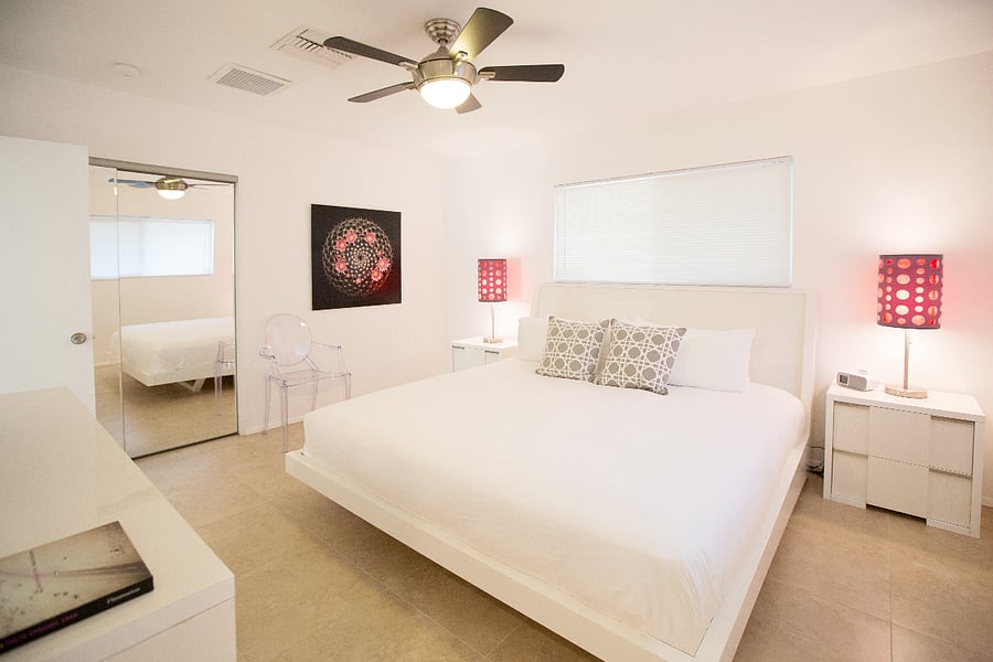 2nd Primary Suite with ensuite bathroom and beautiful view of citrus trees, north lawn, and swimming pool. Features large closet and flatscreen TV.